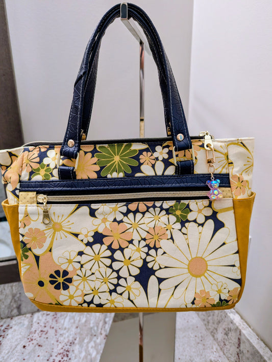 Floral patterned handbag on a stand with a white background